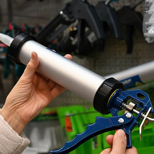 The sealant gun is closed in close-up.